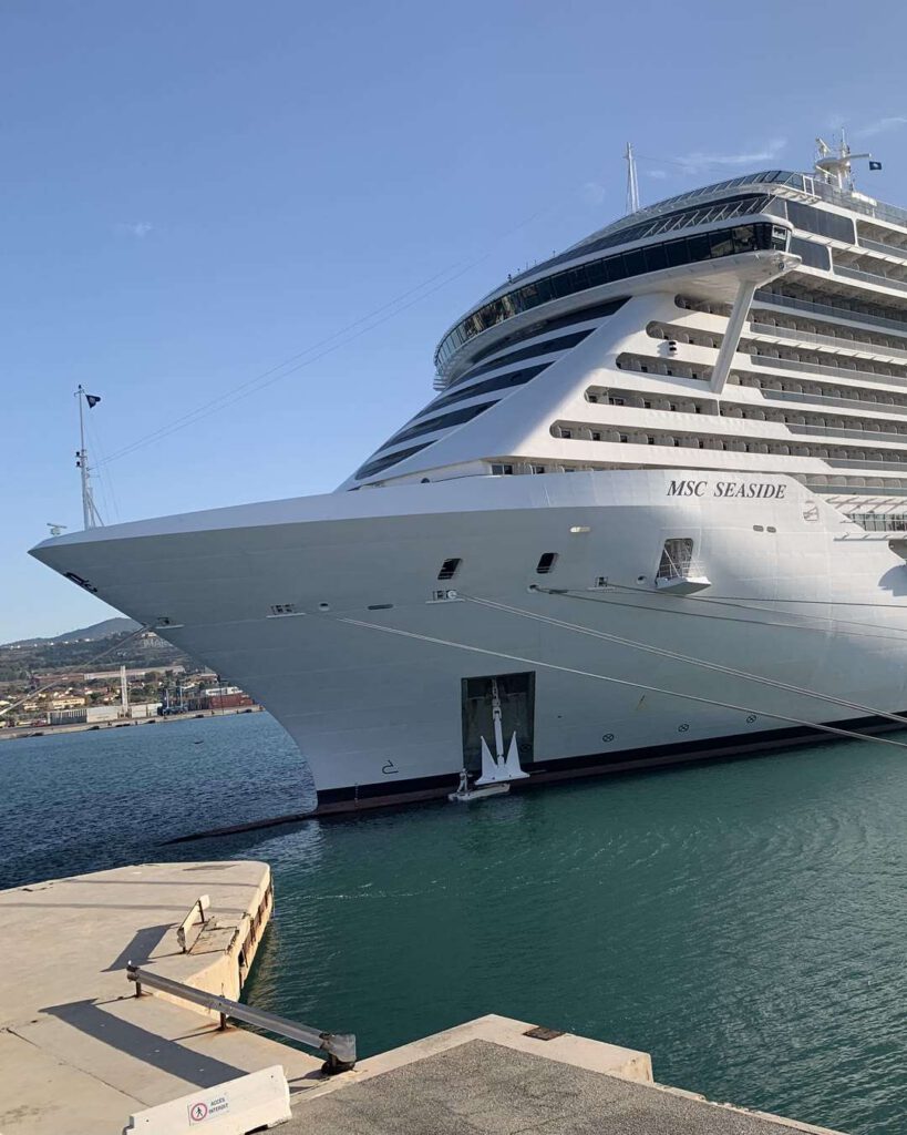 Paquebot de croisière MSC Seaside à quai, proue blanche imposante se reflétant dans l'eau du port