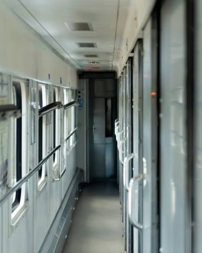 Couloir d'un train de nuit, lumières tamisées, portes des compartiments alignées